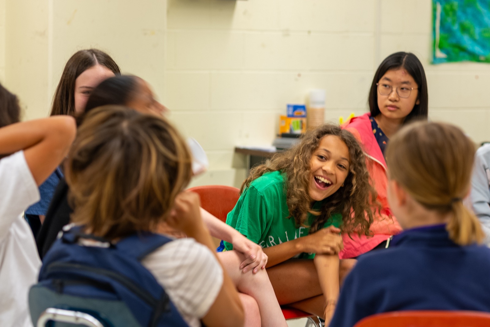 Campers laugh together during a seated discussion circle.